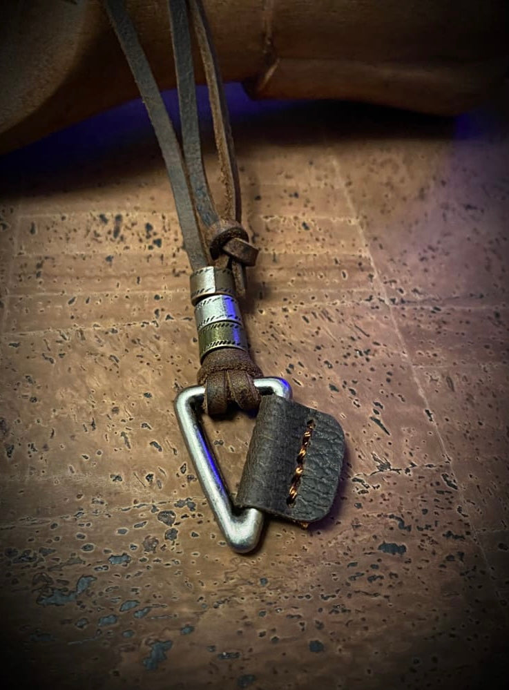 A Valknut silver triangle pendant with an interlocking leather piece on a knotted cord with silver rings.